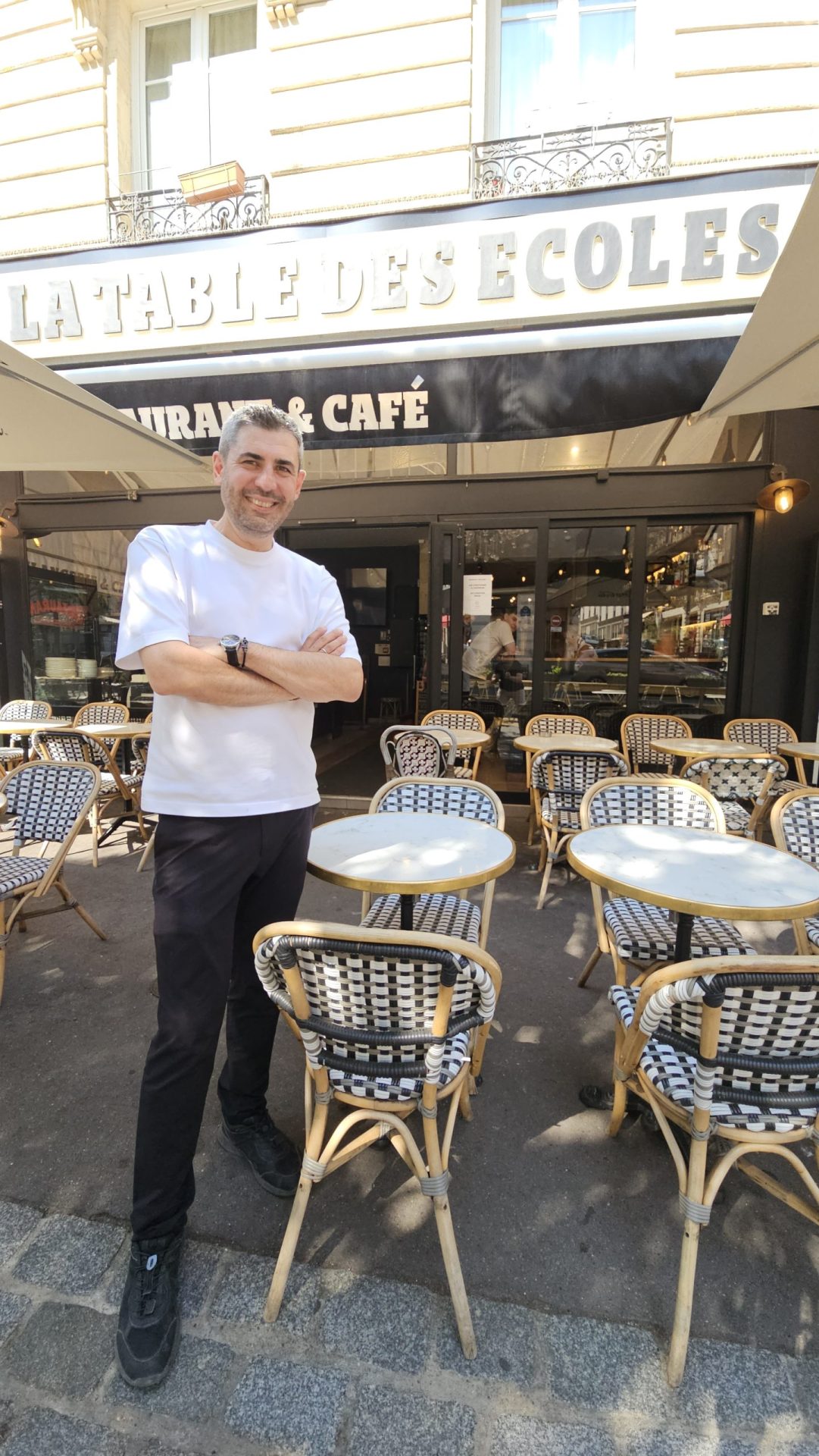 Tolga, fondateur de La Table des Écoles, devant sa brasserie dans le Quartier Latin